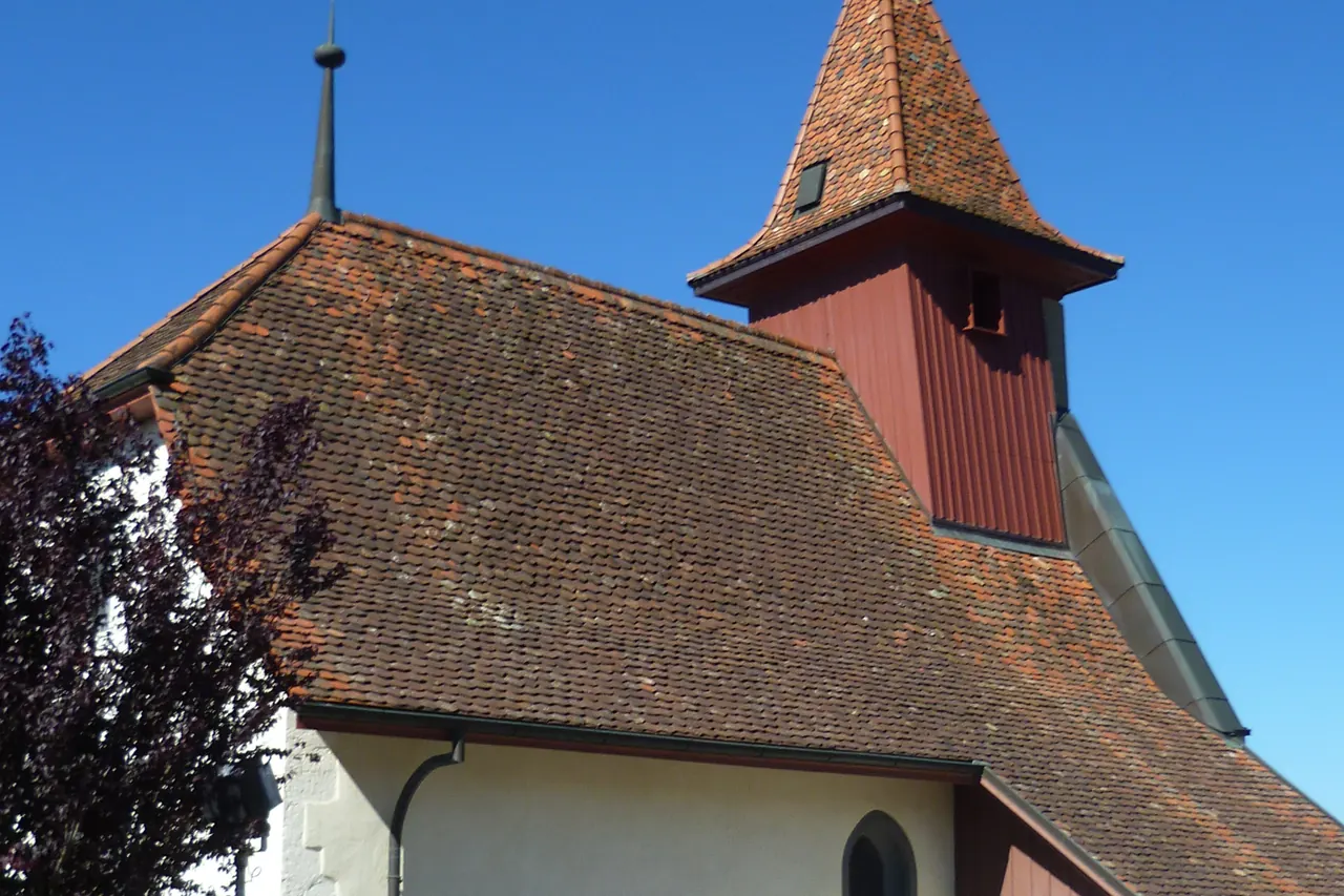 L’église de Belmont-sur-Lausanne et sa toiture en tuiles, sous un ciel bleu