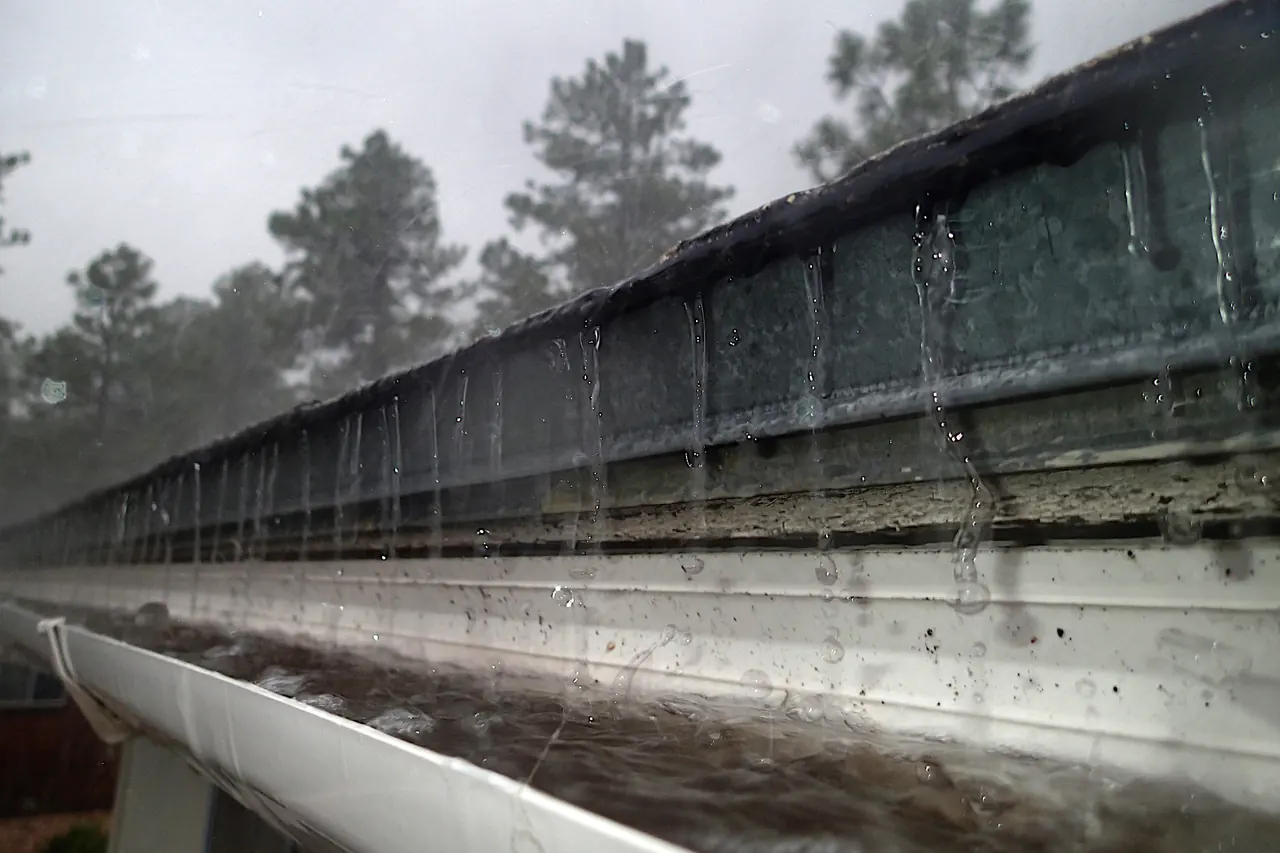 Gouttière recevant l’eau de pluie sur toute la longueur d’un large avant-toit