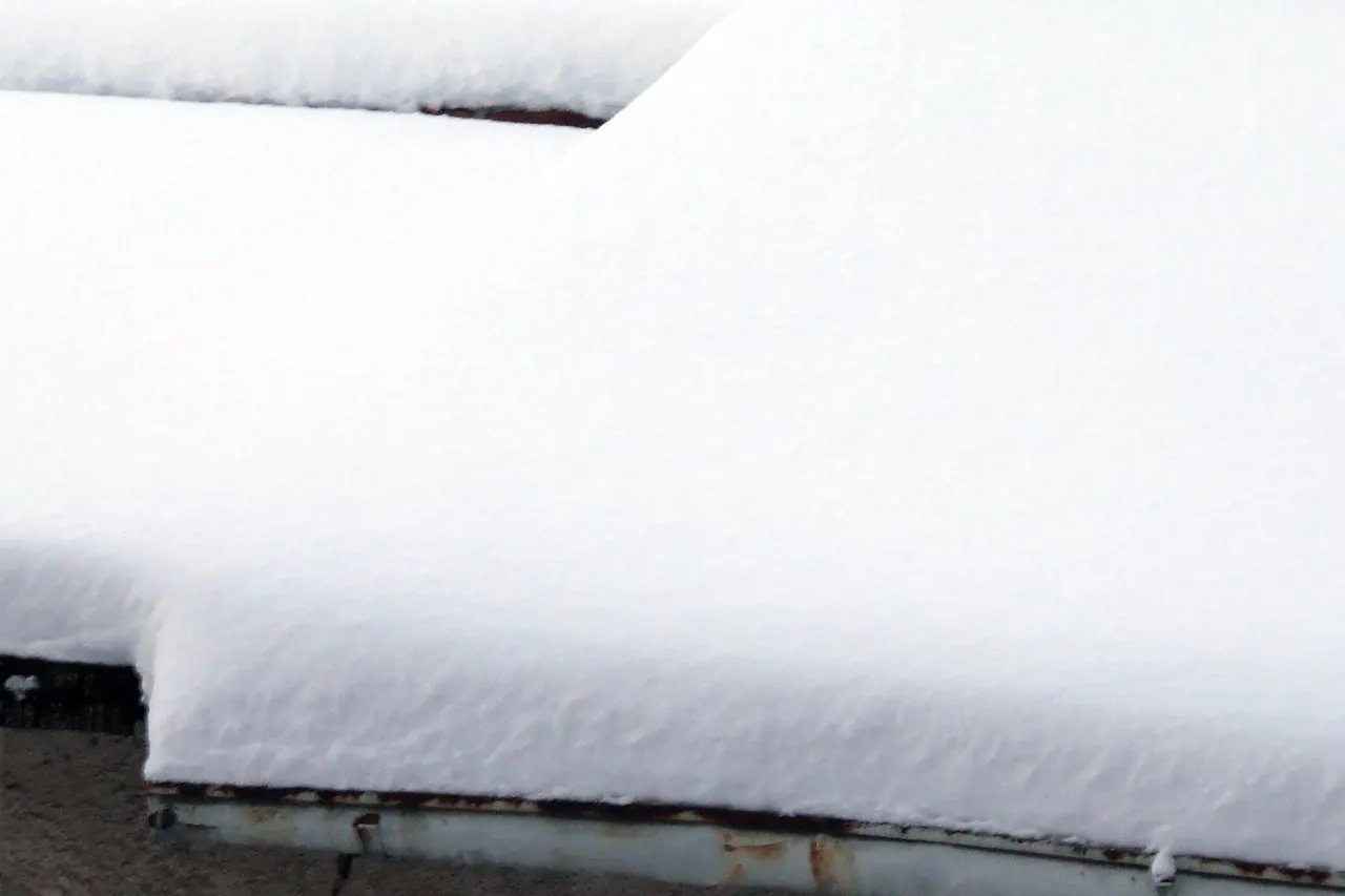 Épaisse couche de neige en surplomb au bord d’une toiture