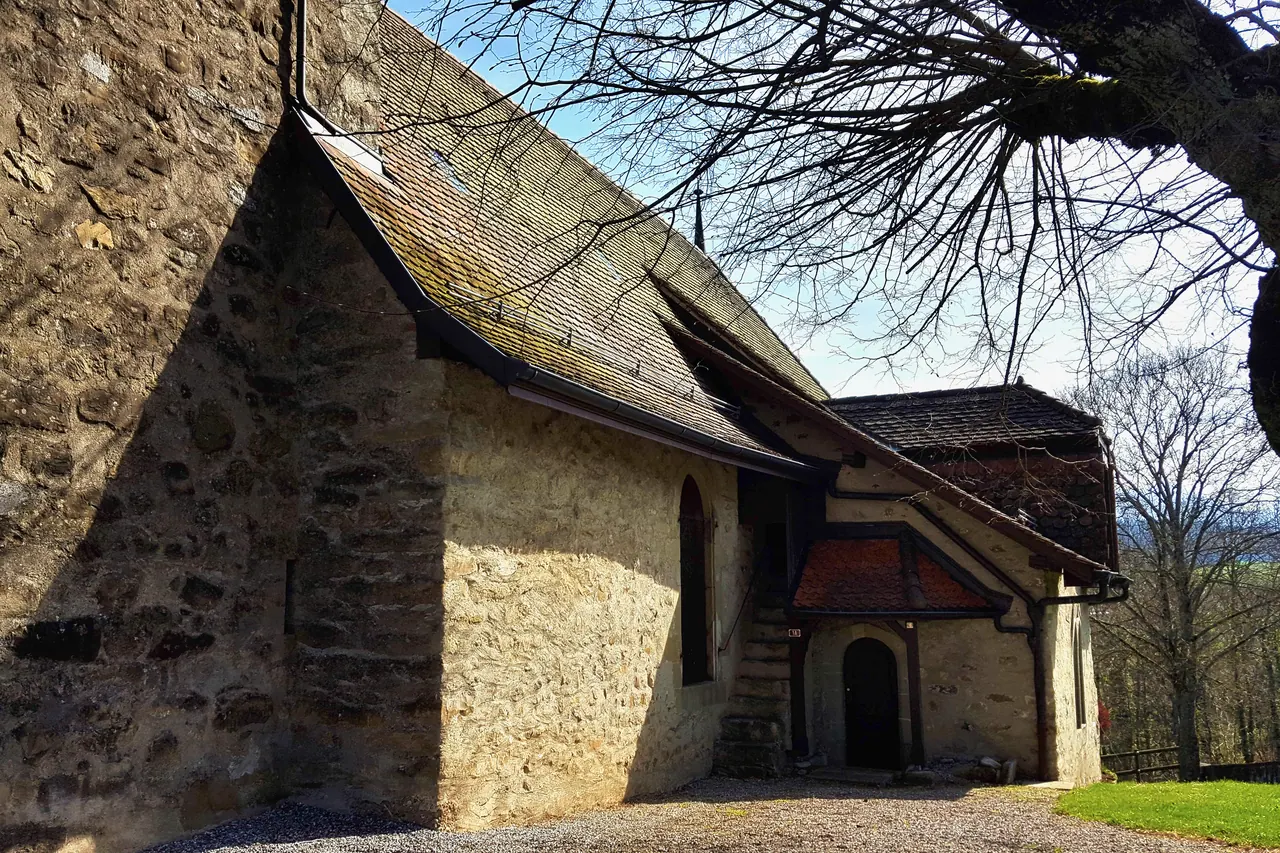 L’église Saint-Maurice de Châtillens, vue de côté, avec son mur de pierre et sa longue toiture