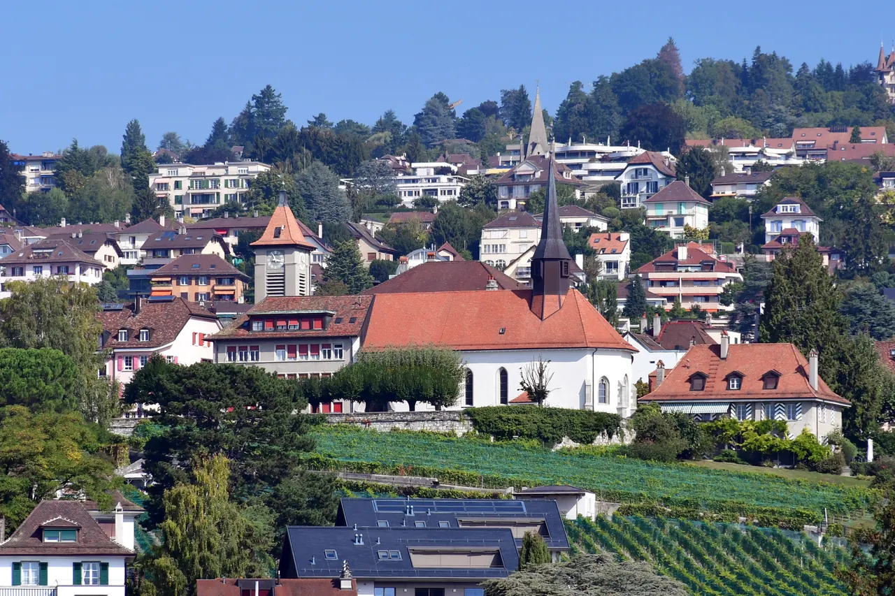 Pully vue depuis les hauts : l’église du Prieuré, les toits de la commune et le lac