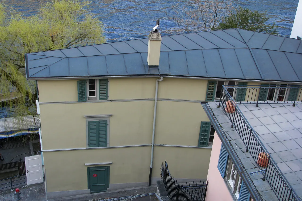 Bâtiment suisse coiffé d’une toiture métallique claire, vu depuis les hauteurs